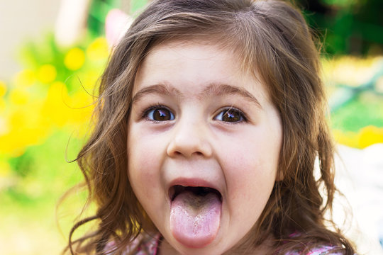 Portrait of cute baby girl with tongue sticking out