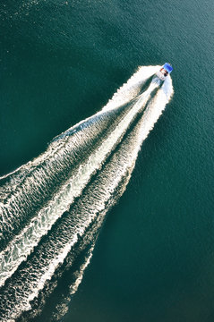Fototapeta Motorówka pozostawiająca ślad na błękitnym oceanie.