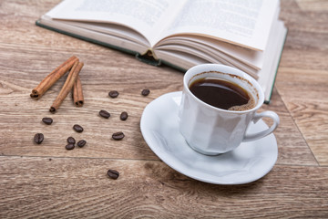 A cup of coffee and cinnamon with a book