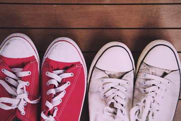 Old canvas shoes on a wooden floor Vintage Retro Filter.