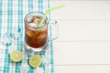 Cold ice tea with lemon on a white wooden table