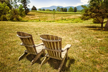 Vineyard landscape with two Adirondack chairs in the foreground facing the view