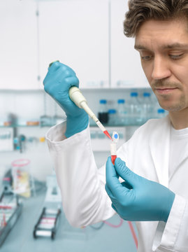 Young male scientist or graduate student with pipette