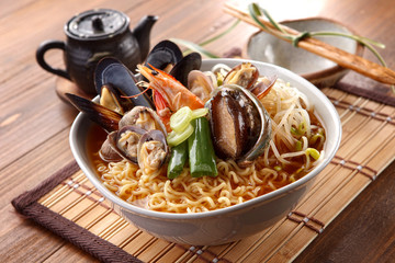 Big bowl of instant noodle with abalone, shrimp, clams, onion an
