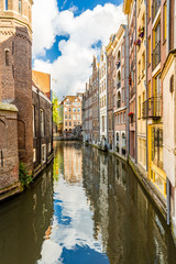 Fototapeta premium Narrow Amsterdam canal and dutch medieval architecture on a sunny morning