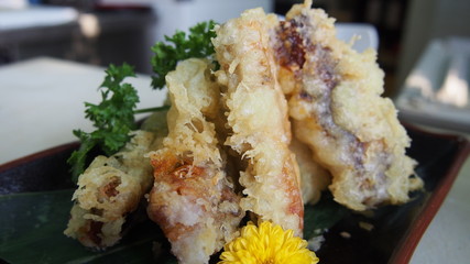 Japanese Anago Tempura of fish and vegetables on black dish in r