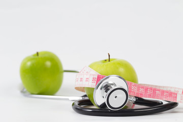 Medical stethoscope and tape measure fat for apple healthy food  background isolated.