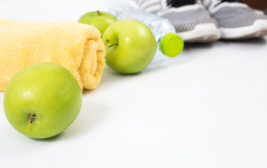 Fitness and health concept. water bottle, smartphone, headphones , running shoes and fruit health diet concept on background isolated.