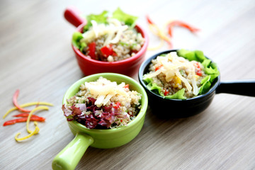 Claypot of colorful salad on wooden table in restaurant