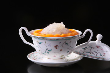 Mixed sweet fruit juice in chinese cup on black background