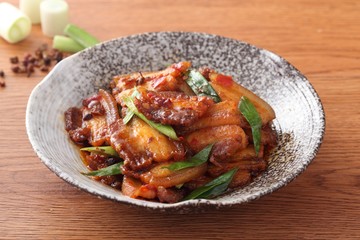 Plate of stewed pork with onion and green bean on the table