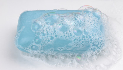 Blue soap with soap bubbles on white background