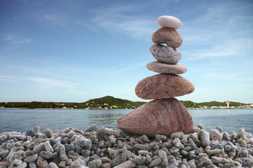 Balance stone on pile rock with sea background.