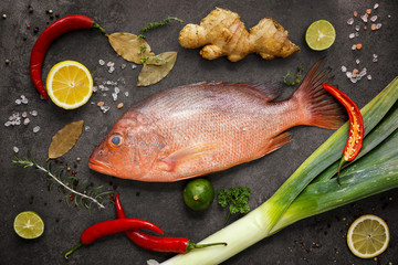 Fresh ingredients to cook fish, red snapper, leak, lime, lemon, - obrazy, fototapety, plakaty