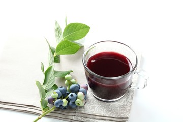 Blueberry juice with raw fruit and tea cup on white background