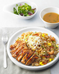 Fried chopped chicken with teriyaki rice on white plate