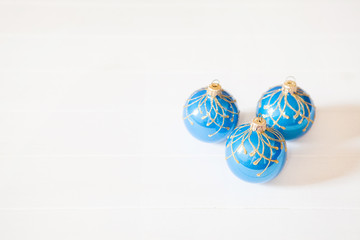 Three blue christmas balls on white wooden background with copy space. Sale concept.