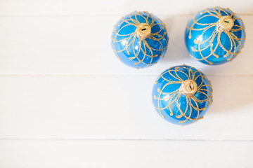 Three blue christmas balls on white wooden background with copy space. Sale concept.
