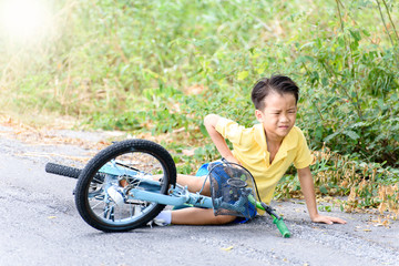 Boy fall from the bicycle during ride on the road