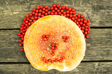 Funny face made from  mushrooms, berries and leaves .On the wooden background