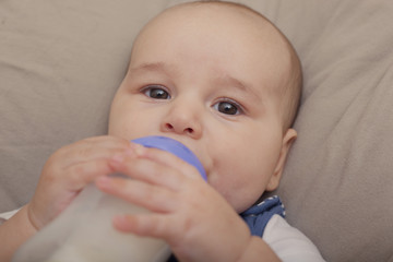 Baby boy drinking milk from the bottle