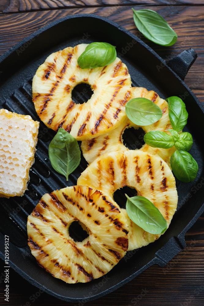 Poster Closeup of grilled pineapple with addition of honey and basil