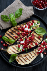 Grilled aubergine with pomegranate, sour cream, nuts, above view