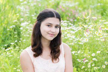 girl sits on richly meadow