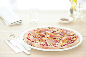 Mushroom pizza on white plate in the restaurant