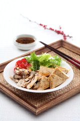 Tofu Salad line with lettuce and sliced tomato on bamboo tray in