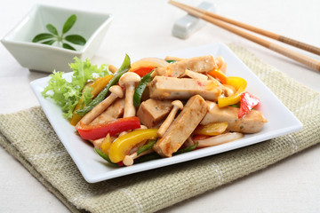 Mushrooms sauteed tofu cheese with chili and lettuce on white pl