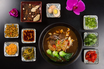 Oriental beef noodles with garlic, chili sauces, egg and herbs o