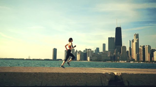 Runner athlete running at seaside with skyscrapers on the background