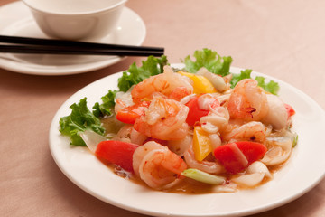 Fried lily shrimp with tomato and lettuce on white plate