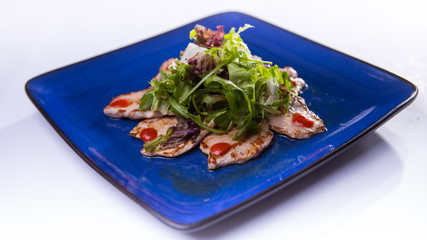 Pork with ginger and mix salad  on blue chinese plate on white b