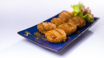 Karaoke with miso dressing and potato croquettes on blue chinese