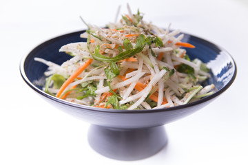 Daikon salad  on blue chinese plate on white background