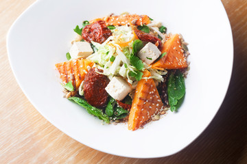 Salad with pumpkin and chickpeas on white plate