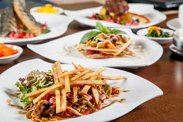 Korean beef salad with fried potatoes on white plate