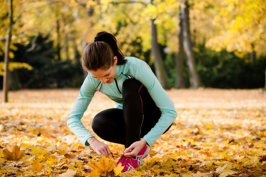 Woman tying shoelaces - jogging in nature