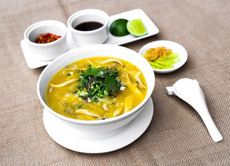 Vietnamese clams porridge in white bowl with lemon and chili sau
