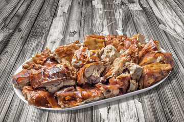 Plateful of Spit Roasted Pork Slices On Old Wooden Background