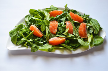 Arugula caracara oranges on white plate and background