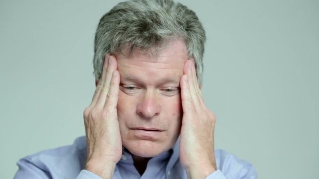Man with headache rubs his head