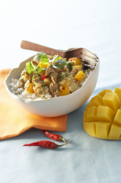 Spicy veal sauteed with mango on white bowl with dried chili
