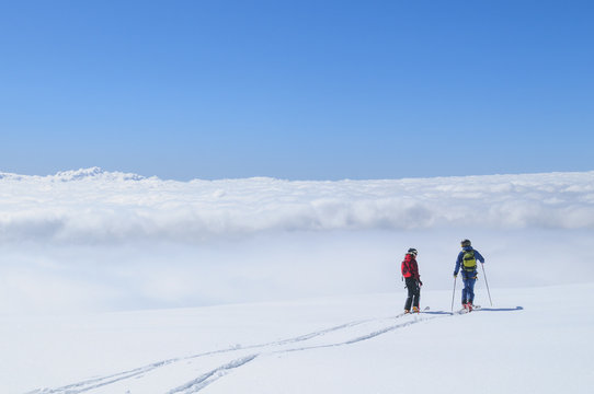 Zwei einsame Freeskier genießen die grenzenlose Freiheit über den Wolken