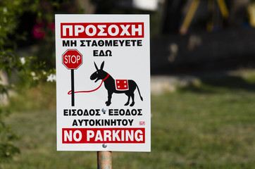 Sign for no parking in greek, in graphic shows a donkey tied to a pole Stop