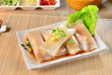 Fresh rolls of Pho with soyal sauce and green lettuce on white p