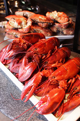 Steamed red lobsters and crabs on white plate in restaurant