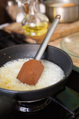 Fried onions in a frying pan, which stands on a gas stove